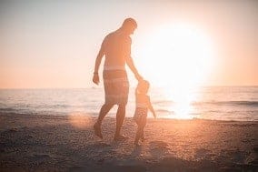 marido paseando con el niño por la playa
