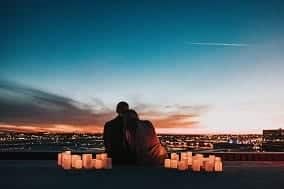 pareja sentada viendo el atardecer