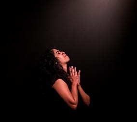mujer rezando durante la medianoche
